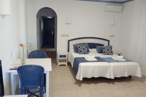 a bedroom with a bed and a table and chairs at Hotel Marazul in Mojácar