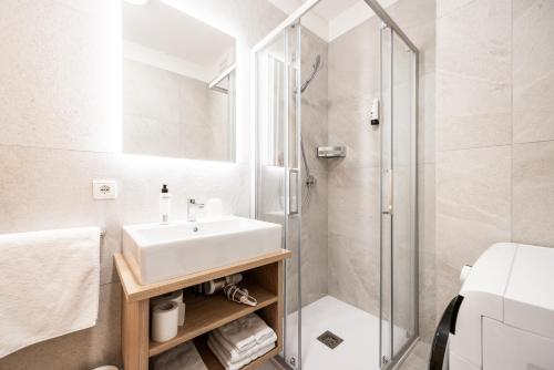 a bathroom with a sink and a shower at Pixner Apartments in Bolzano
