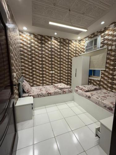 a room with two beds on the wall at غرفتين وصالة النبلاء in Medina