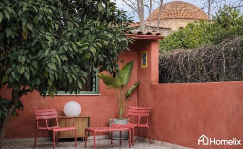 a group of red chairs and a table with a plant at Santa Clara - the revolution of living in Chalkida