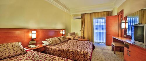 a hotel room with two beds and a television at Hedef Resort Hotel in Konaklı