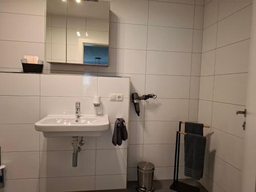 a white bathroom with a sink and a mirror at Apart van der Heyd in Prutz