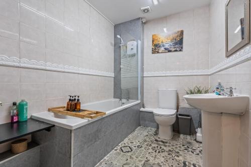 a bathroom with a sink and a toilet and a tub at 3BR Pontypool Haven - Sleeps 6 with Parking in Pontnewynydd
