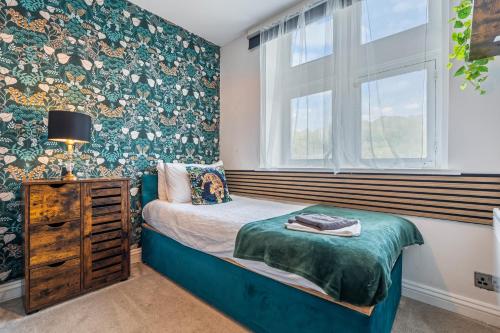 a small bedroom with a bed and a window at 3BR Pontypool Haven - Sleeps 6 with Parking in Pontnewynydd