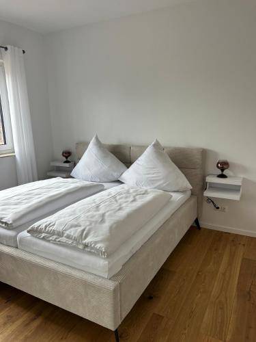 a bedroom with a large bed with white sheets and pillows at Haus am Meer mit Sauna in Koserow in Koserow