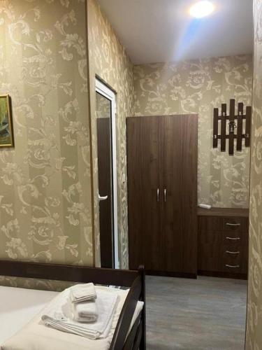 a bedroom with a bed and a bathroom with wallpaper at Апартамент за гости КРИСИ - Apartment for rent KRISI in Vidin