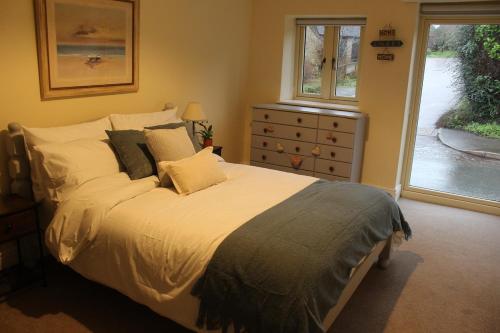 a bedroom with a bed and a dresser and a window at Charming Converted Stable in Ramsbury for Two in Ramsbury