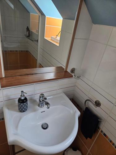 a bathroom with a white sink and a mirror at chambres évènements circuit LE MANS in La Milesse