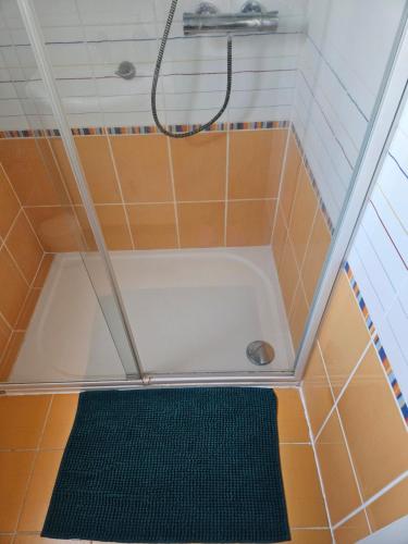 a shower with a tub in a bathroom with orange tiles at chambres évènements circuit LE MANS in La Milesse