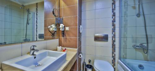 a bathroom with a sink and a toilet and a shower at Hedef Resort Hotel in Konaklı