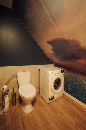 a bathroom with a toilet and a washing machine at Morze Tu in Stegna