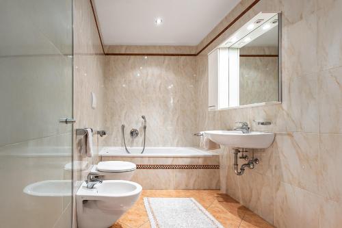 a bathroom with a sink and a toilet and a tub at Biene Natururlaub am Moosbachhof mit Dolomitenblick in Collalbo
