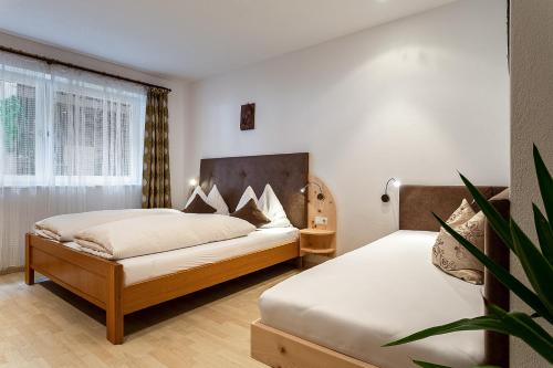 a bedroom with two beds and a potted plant at Biene Natururlaub am Moosbachhof mit Dolomitenblick in Collalbo