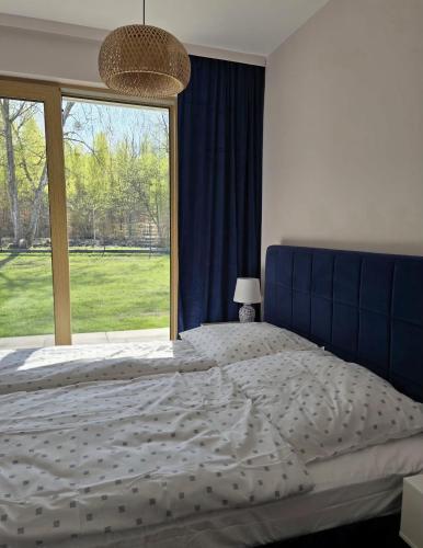 a bedroom with a large bed with a large window at Apartamenty Miku - Łeba in Żarnowska