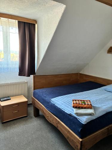 a bedroom with a bed with a blue comforter at Hotel Chata ve Volarech Šumava in Volary