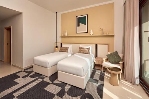 a hotel room with a bed and a couch at Daraah Resort - AMAALA in Ţaraf Shaqq al ‘Abd