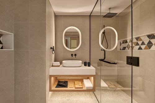 a bathroom with a sink and a shower at Daraah Resort - AMAALA in Ţaraf Shaqq al ‘Abd