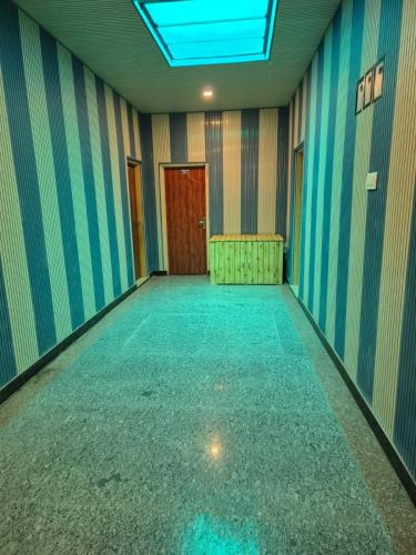 an empty room with blue and striped walls and a door at Hotel Dilli Darbar and Restaurant in Bandipura