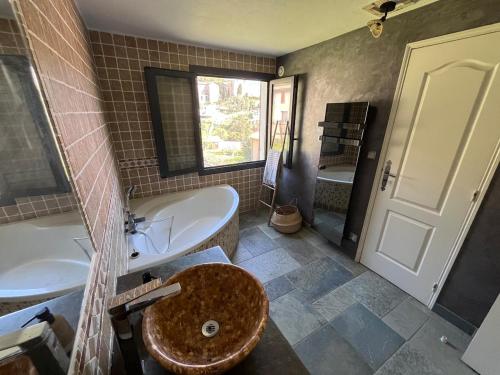 a bathroom with a sink and a tub and a toilet at Maison Erbalunga in Brando