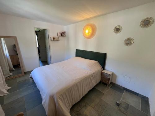 a bedroom with a white bed in a room at Maison Erbalunga in Brando
