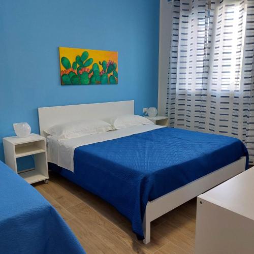 a blue bedroom with a bed and a blue wall at Blue Sicily Apartment in Roccalumera