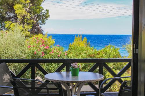 a table on a balcony with a view of the ocean at Anthema Apartments in Kalogria