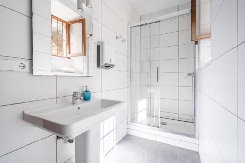 a white bathroom with a sink and a shower at Hostal Miramar in Deia