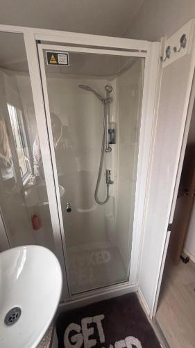 a bathroom with a shower and a white sink at Lyons Robin Hood Hazel Park 6 in Rhyl