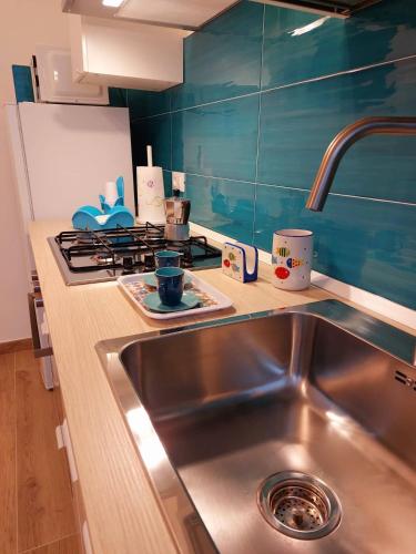 a kitchen with a sink and a stove at Blue Sicily Apartment in Roccalumera
