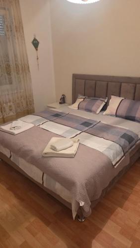 a large bed with two towels on top of it at Apartman Centar LUX in Jagodina