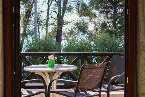 a table and two chairs on a balcony with a table and flowers at Anthema Apartments in Kalogria