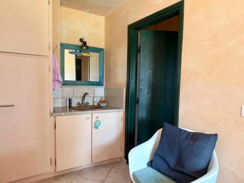a bathroom with a chair and a sink and a mirror at Olive House Galaxidi in Galaxidi
