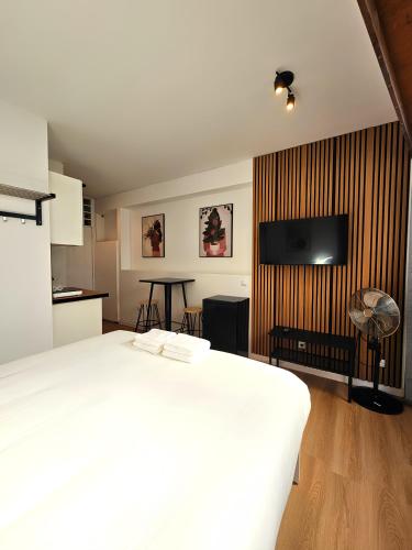 a bedroom with a white bed and a flat screen tv at Porto Automatic in Porto