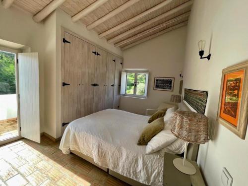 a bedroom with a bed and a table with a lamp at Tina`s House - Bordeira in Aljezur