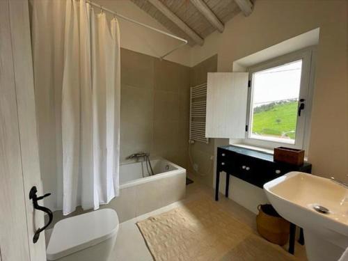 a bathroom with a toilet and a tub and a sink at Tina`s House - Bordeira in Aljezur