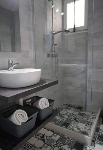 a bathroom with a tub and a sink and towels at Helena's house in Ermoupoli