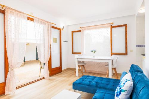 a living room with a blue couch and a table at Apartamento Felipe 1-4 in Cala d´Or