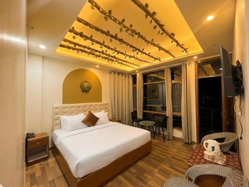 a hotel room with a bed and a television at Siesta B&B Private Balcony & Himalayan Sunrise Views in Shimla