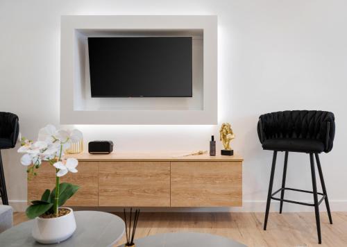 a living room with a tv on a wall at Aura Airport Suite in Spata