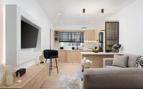 a living room with a couch and a kitchen at Aura Airport Suite in Spata