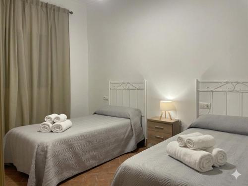 a bedroom with two beds with towels on them at Villa rural en Marchena in Marchena