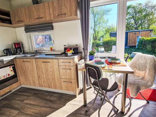 a kitchen with wooden cabinets and a table with chairs at Holiday Home Tiny Haus Heidi by Interhome in Beilngries