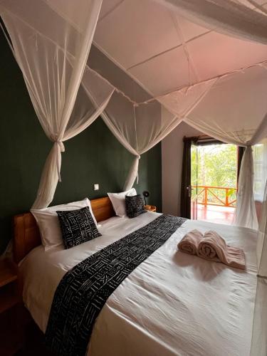 a bedroom with a large bed with a canopy at Rutete Eco Lodge in Rwinkwavu