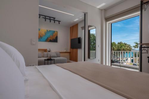 ein Schlafzimmer mit einem großen Bett und einem Balkon in der Unterkunft WALK2BEACH Riviera Beachfront Luxury Studio Suite - Steps to Yabanaki Varkiza in Varkiza