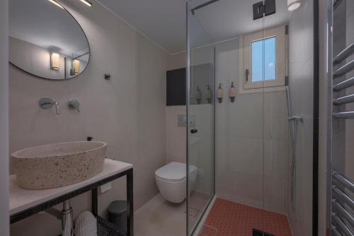 ein Badezimmer mit Waschbecken, Toilette und Spiegel in der Unterkunft WALK2BEACH Riviera Beachfront Luxury Studio Suite - Steps to Yabanaki Varkiza in Varkiza