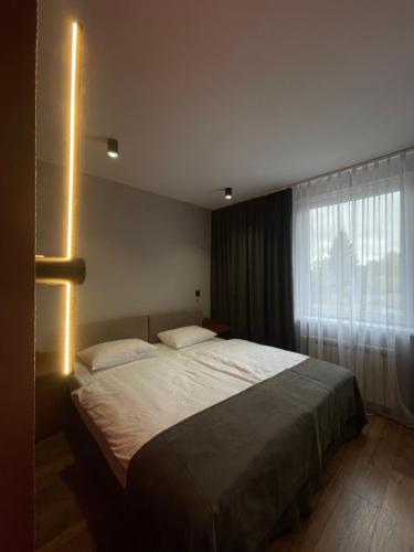 a bedroom with a large bed and a window at Zatyshok Затишок in Rokytne