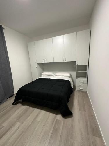 a bedroom with a black bed and white cabinets at Prestige House 6 in Scalea