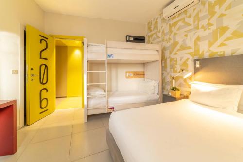 a bedroom with a white bed and a room with bunk beds at HYVE Jerusalem hosted by STAY in Jerusalem
