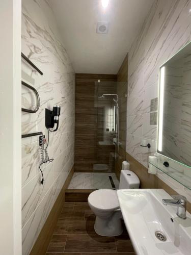 a bathroom with a toilet and a sink and a shower at Zatyshok Затишок in Rokytne