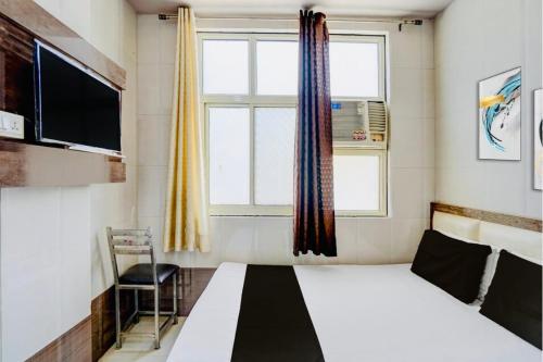 a bedroom with a bed and a tv and a window at Hotel Haji Ali - Sahil inn in Ajmer